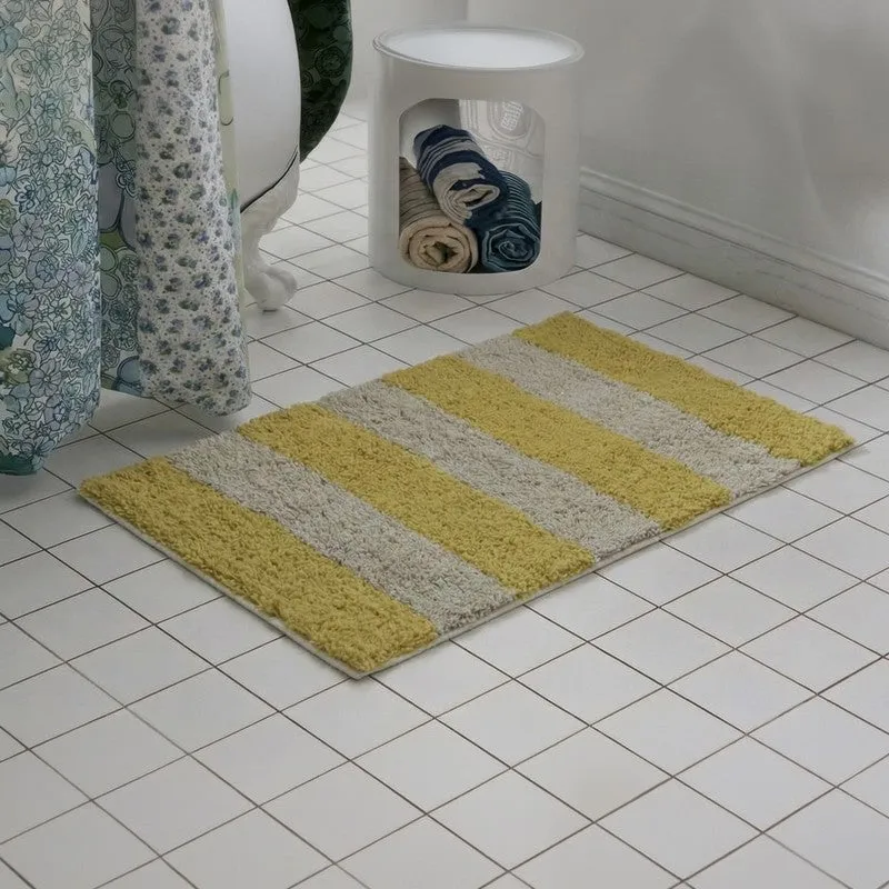 Rectangular yellow and white striped bath mat on tiled floor