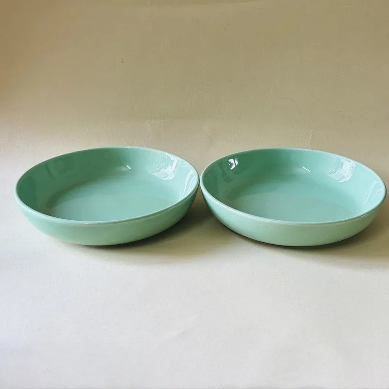 Two green ceramic bowls placed side by side