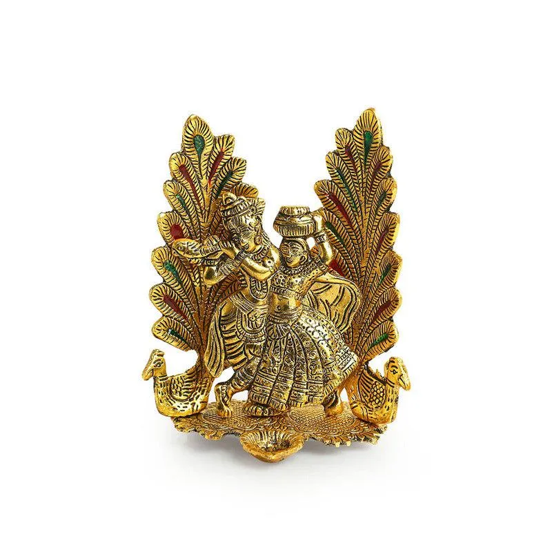Front view of a gold-toned Radha Krishna diya showpiece on a white background