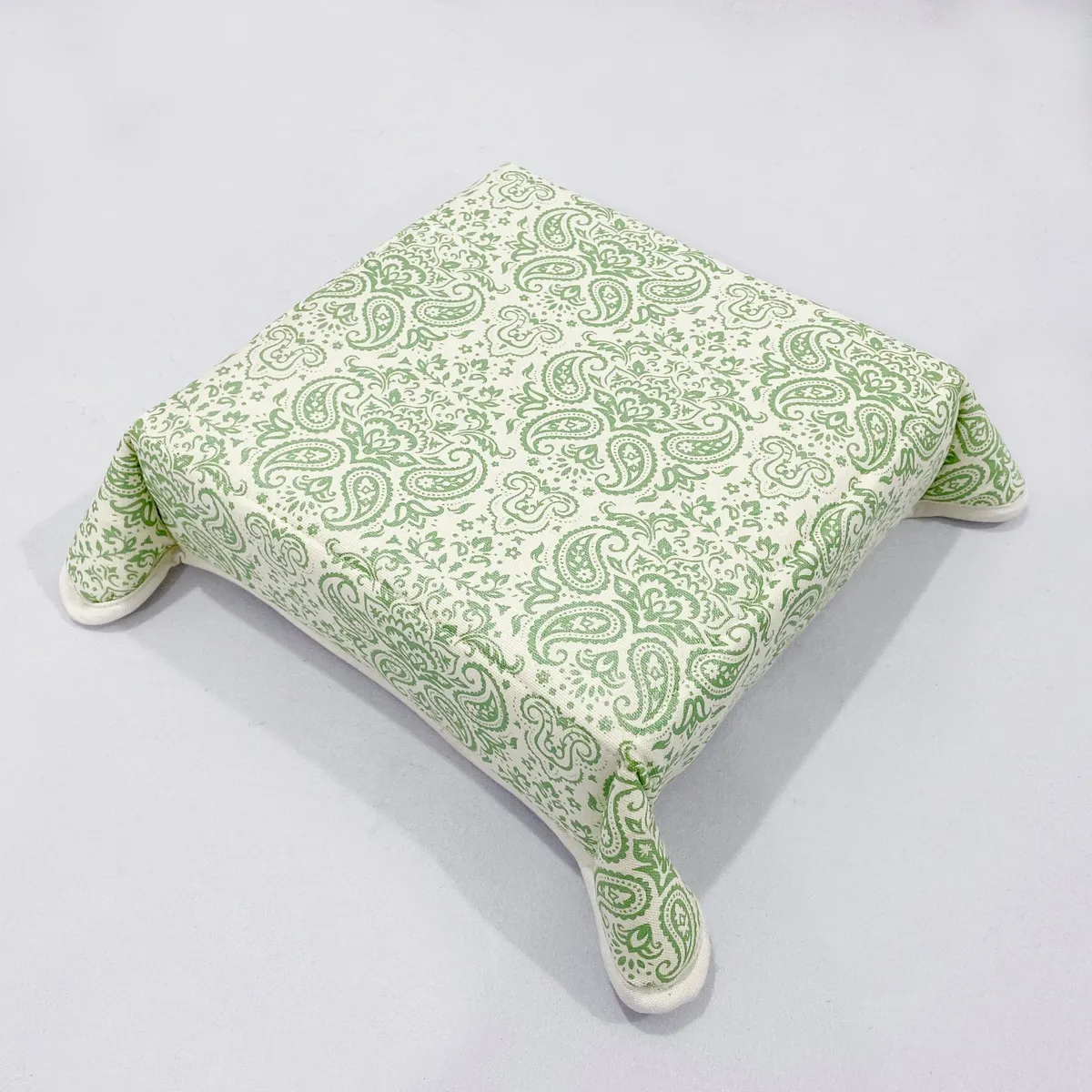 Folded square bread basket in cream and green paisley fabric