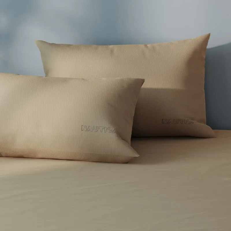 Close-up of two matching khaki pillow covers on the bedsheet