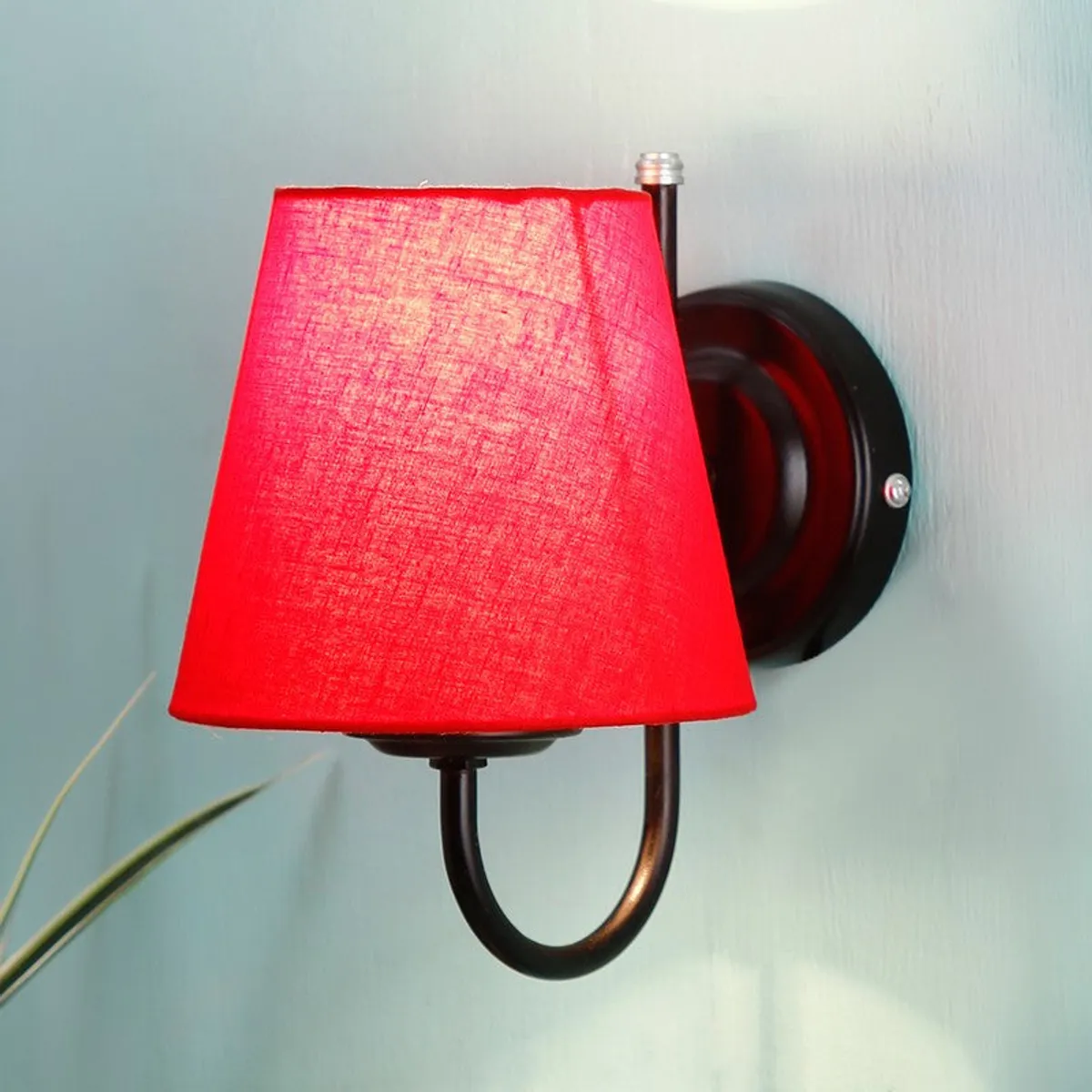 Close-up of red cotton wall lamp with black iron base