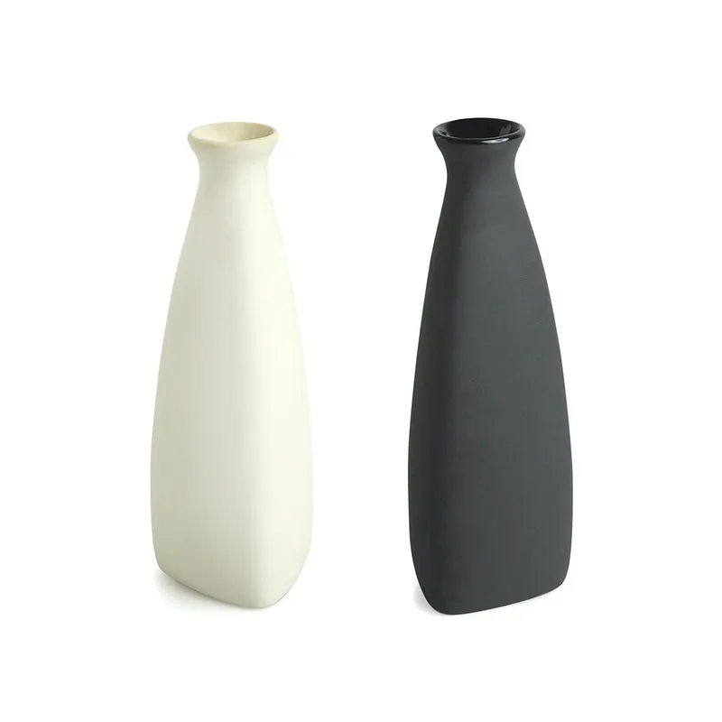 Two tapered ceramic vases in white and black on a plain white background