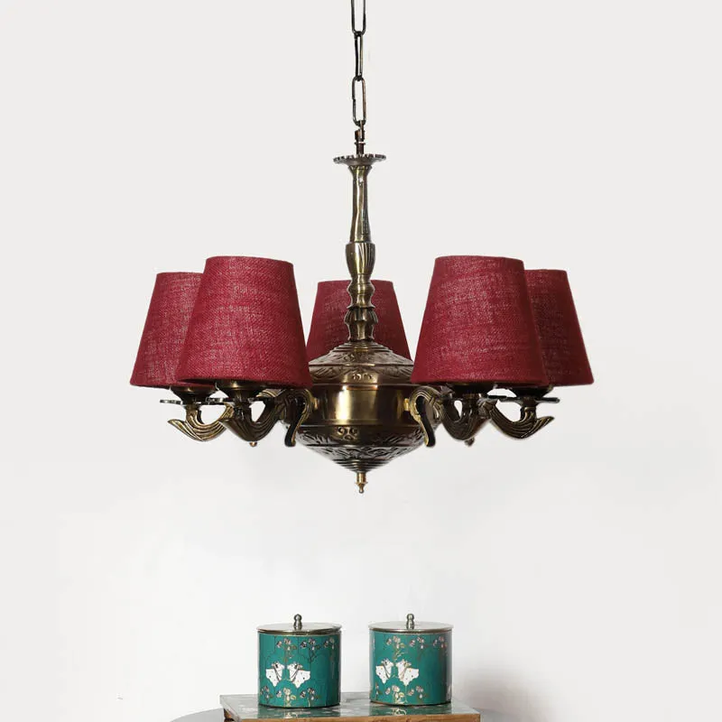Antique gold chandelier ceiling lamp with five maroon conical shades on a white background