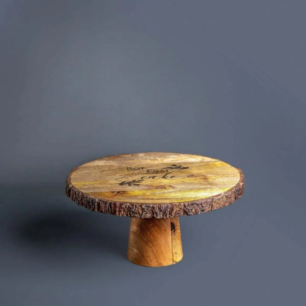 Full view of the round brown mango wood cake stand with a raised base