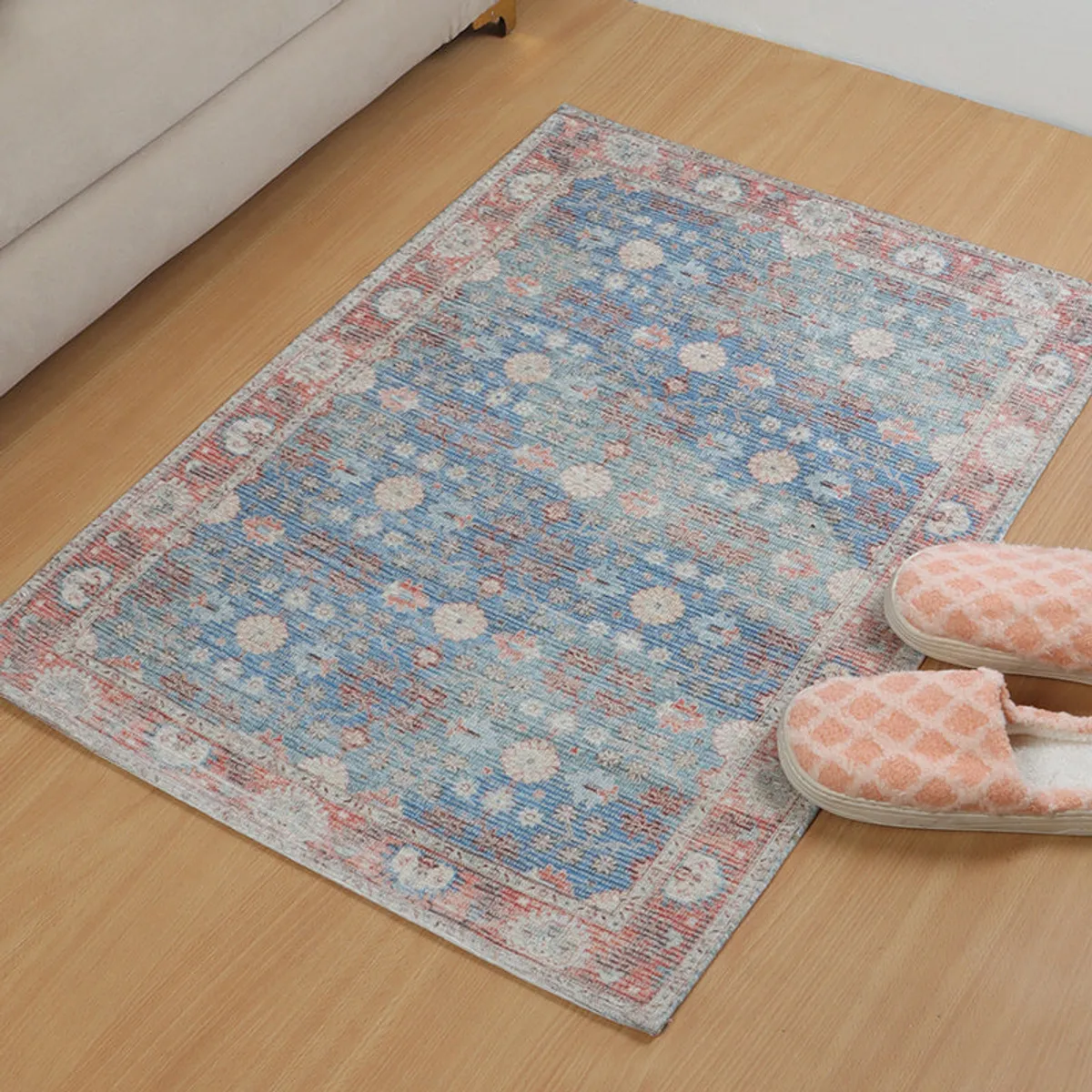 Close view of the rectangular blue and brown patterned mat on a wooden floor.