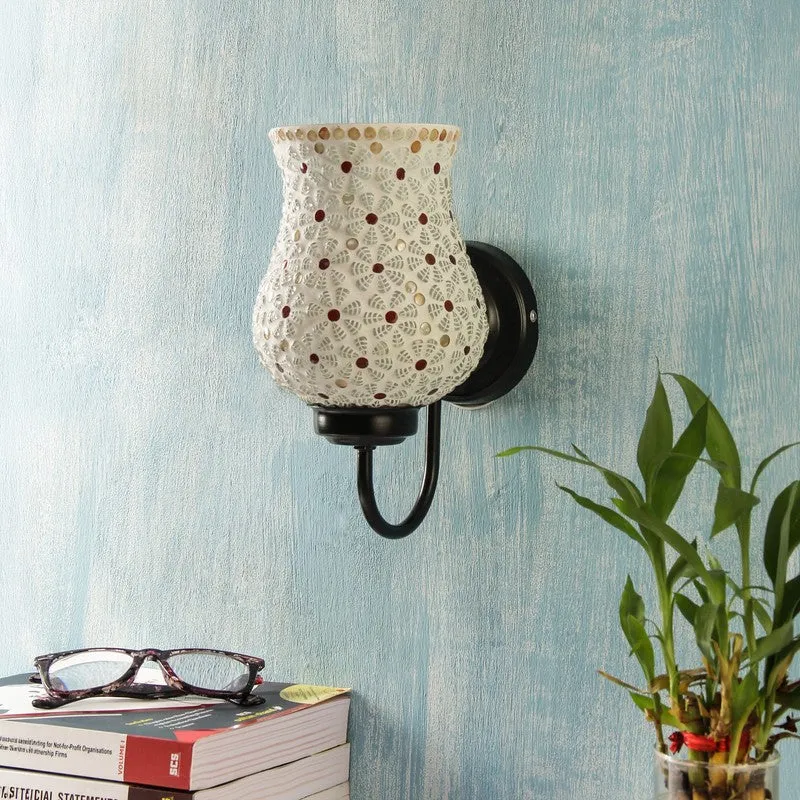 Unlit white mosaic glass wall lamp on a blue wall with floral mosaic pattern