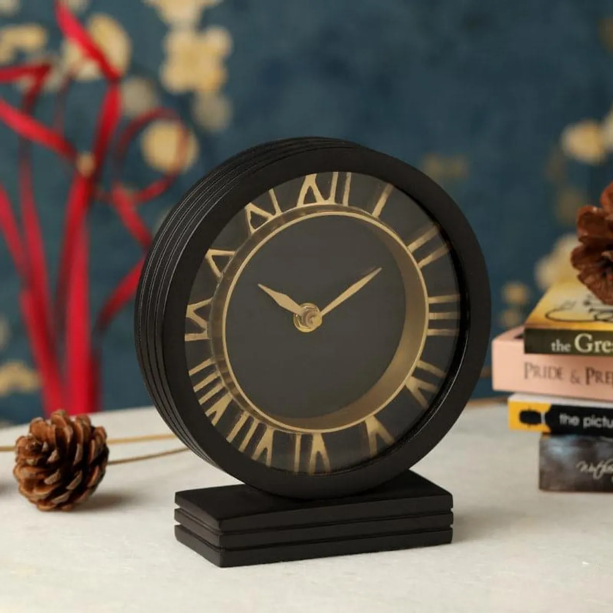 Black vintage-style table clock with gold Roman numerals on tabletop