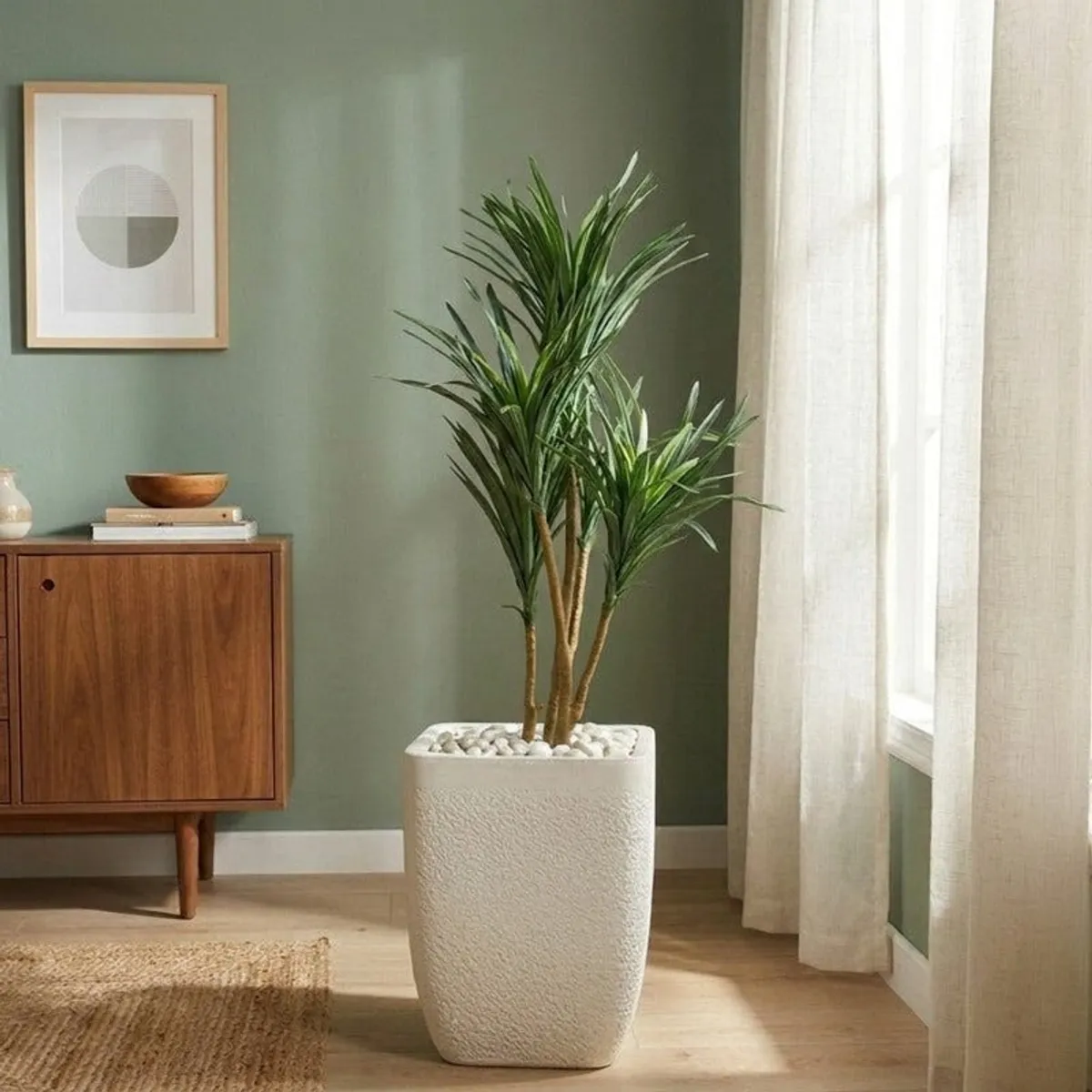 White textured planter holding a tall green plant beside a bright window