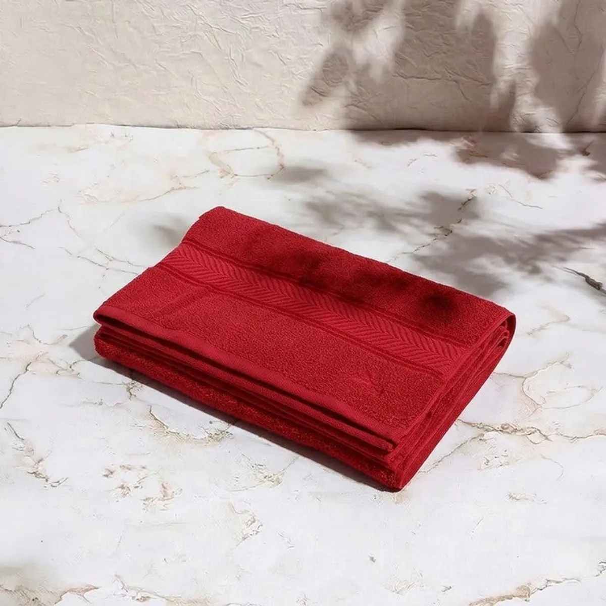 Folded red bath towel showing its textured border detail