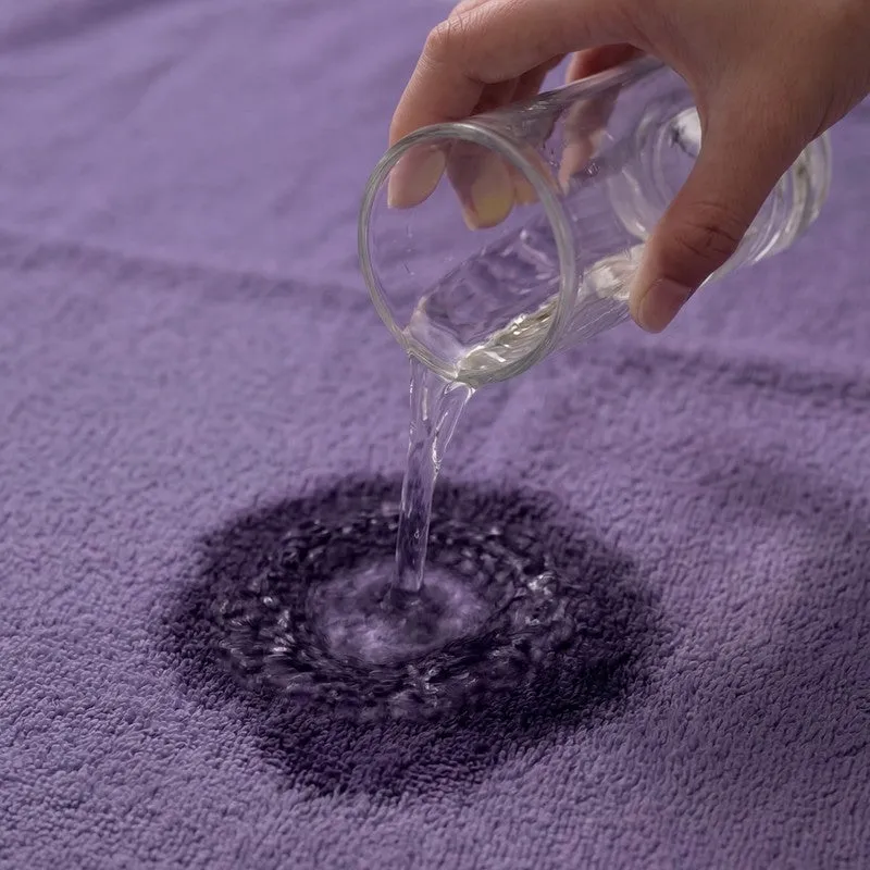 Water being poured onto the surface of a purple towel
