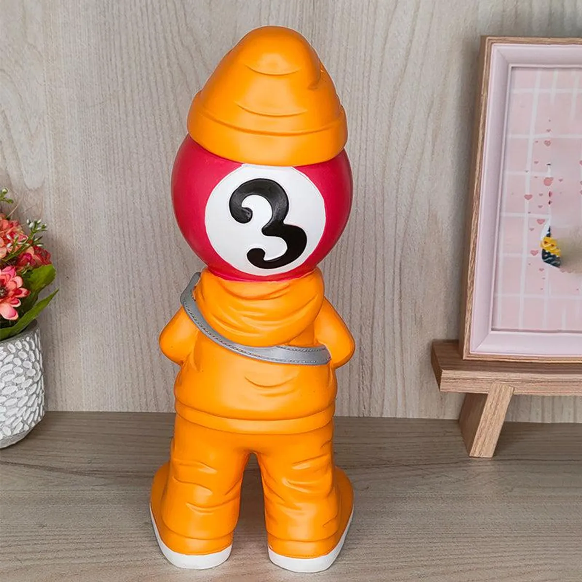 Back view of the yellow-orange figurine showpiece with a red billiards ball head.