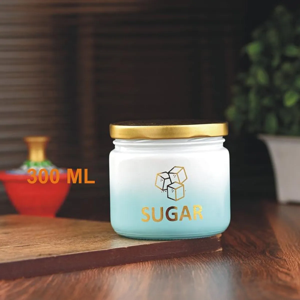 Green gradient sugar jar with gold lid displayed on a wooden table