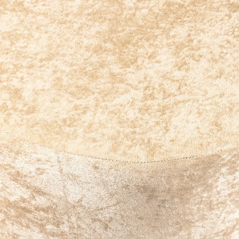 Close-up of the beige velvet upholstered top and side of the ottoman
