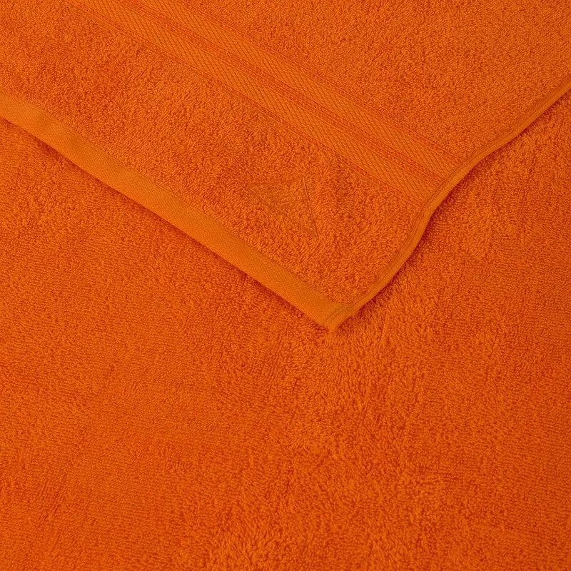 Close-up of the orange towel showing its edging and sewn brand label