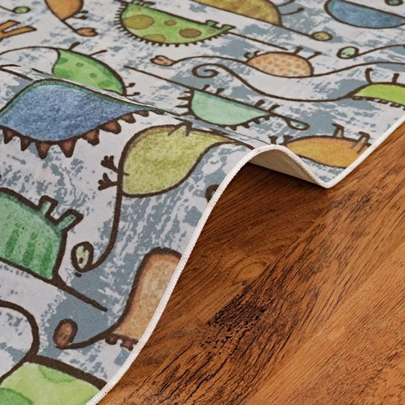 Close-up of carpet edge with dinosaur pattern on wooden floor