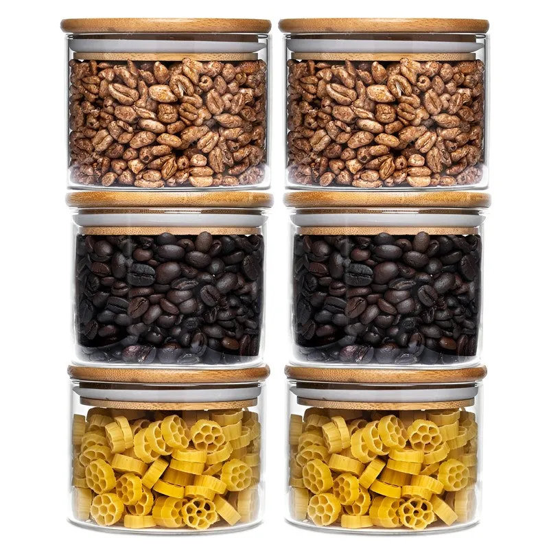 Six clear storage jars with bamboo lids arranged in two columns with snacks and coffee beans