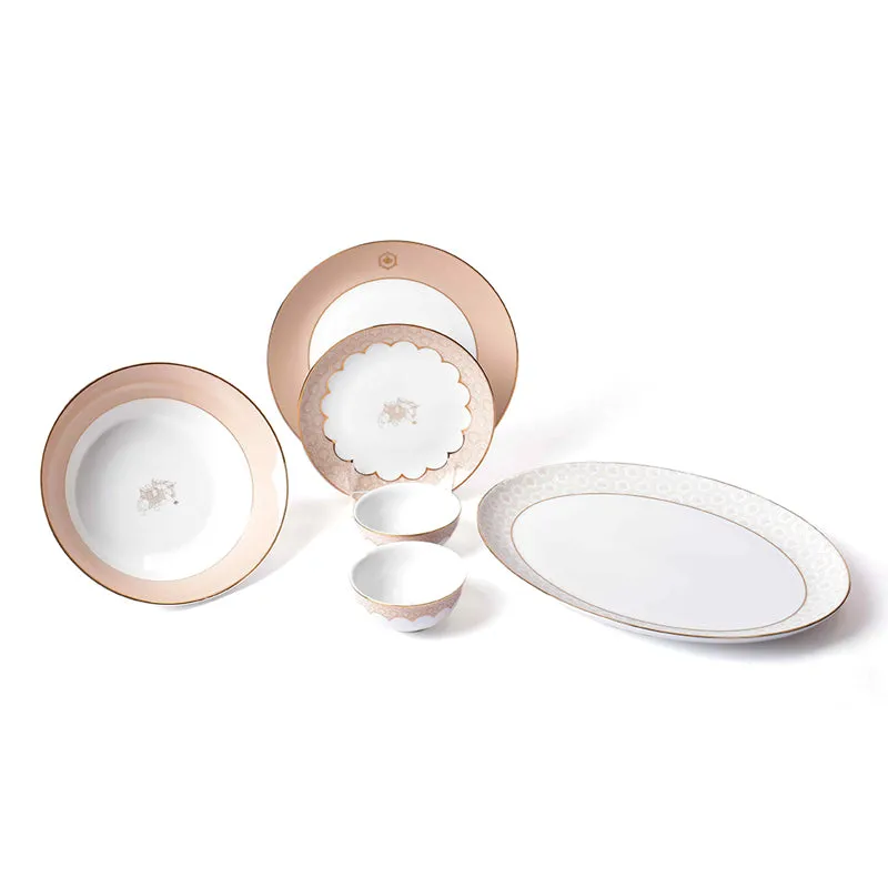 Peach and ivory porcelain dinnerware set with gold detailing and an oval platter