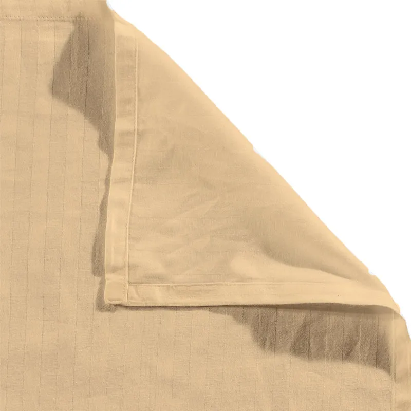 Close-up of the cream bedsheet corner showing subtle striped texture