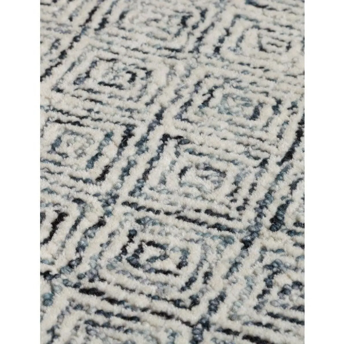 Close-up of the rug's soft grey and white geometric texture