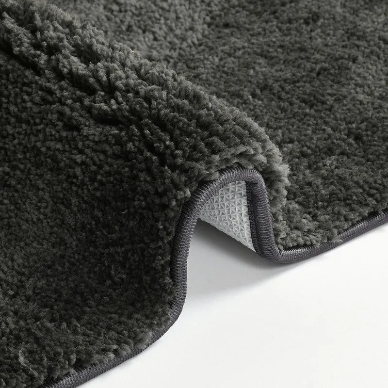 Folded corner of the dark grey bath mat showing thick pile