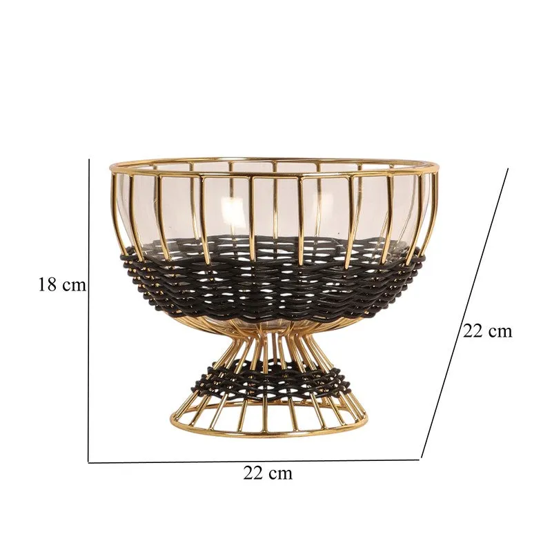 Black and gold glass fruit bowl displayed with fresh fruit in a kitchen setting.