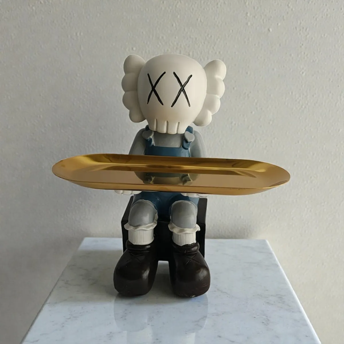 Front view of a cartoon figurine with a reflective gold tray