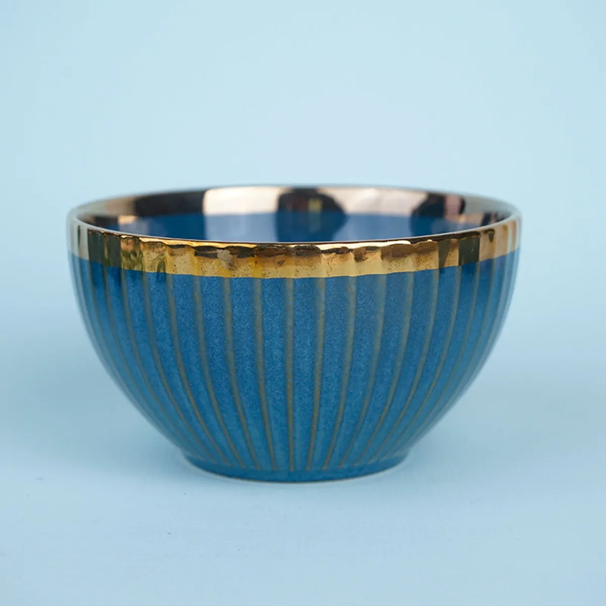 Single blue ribbed serving bowl with a glossy finish and gold rim