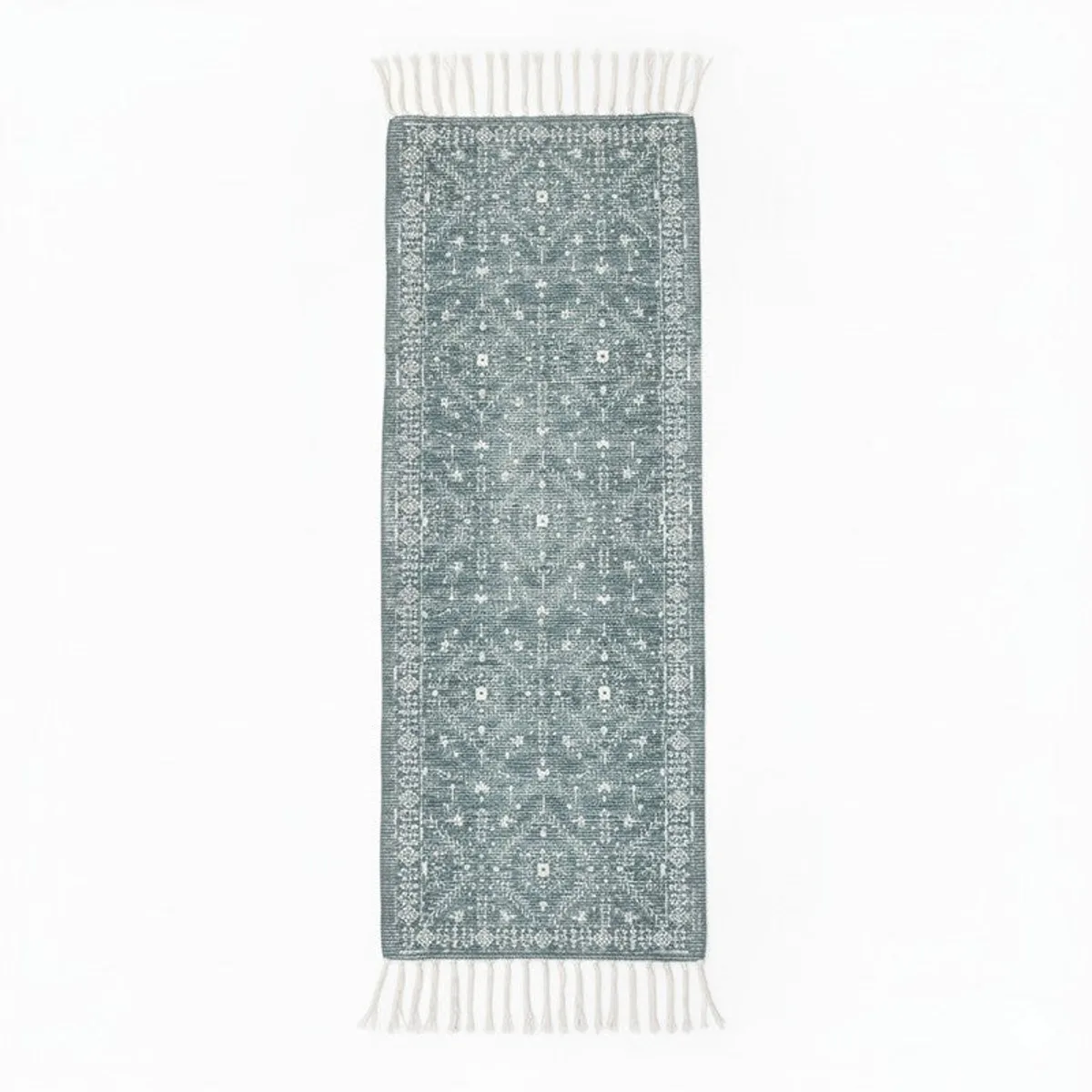 Blue runner rug with white ethnic motif and fringe on both ends