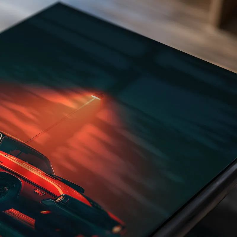 Close-up of a red muscle car poster under a streetlight on a dark background