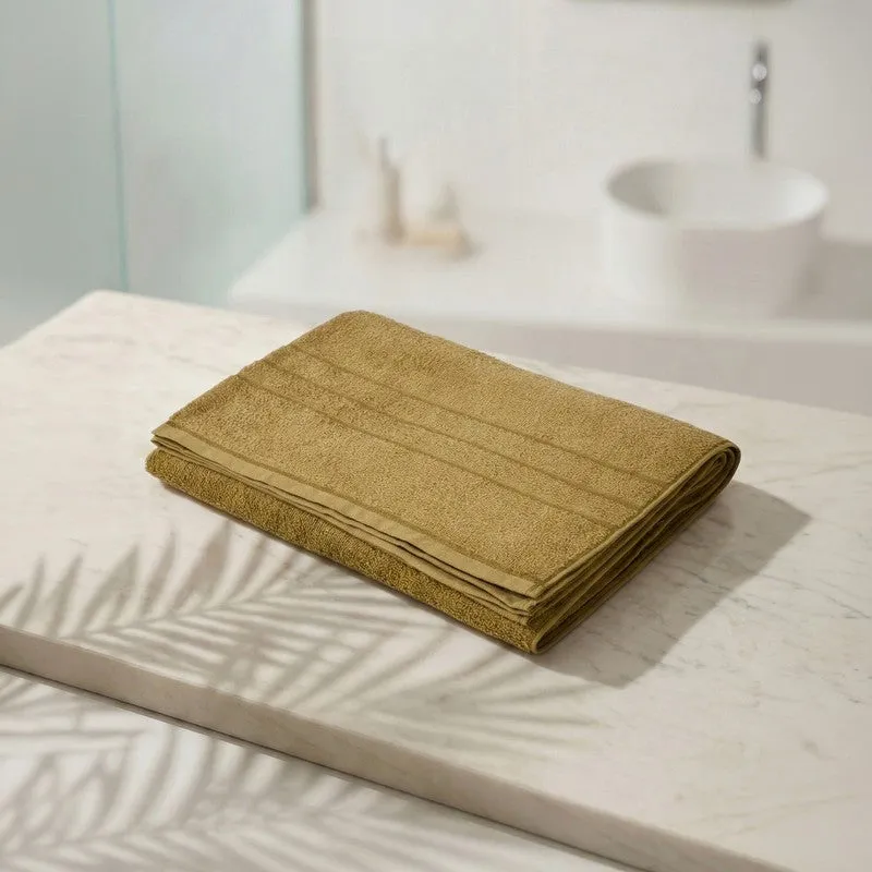 Folded olive green bath towel on a marble surface