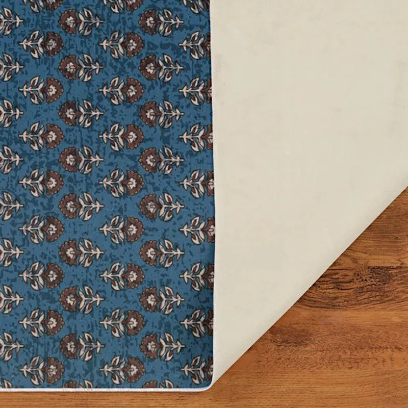Underside view of blue patterned carpet with light backing