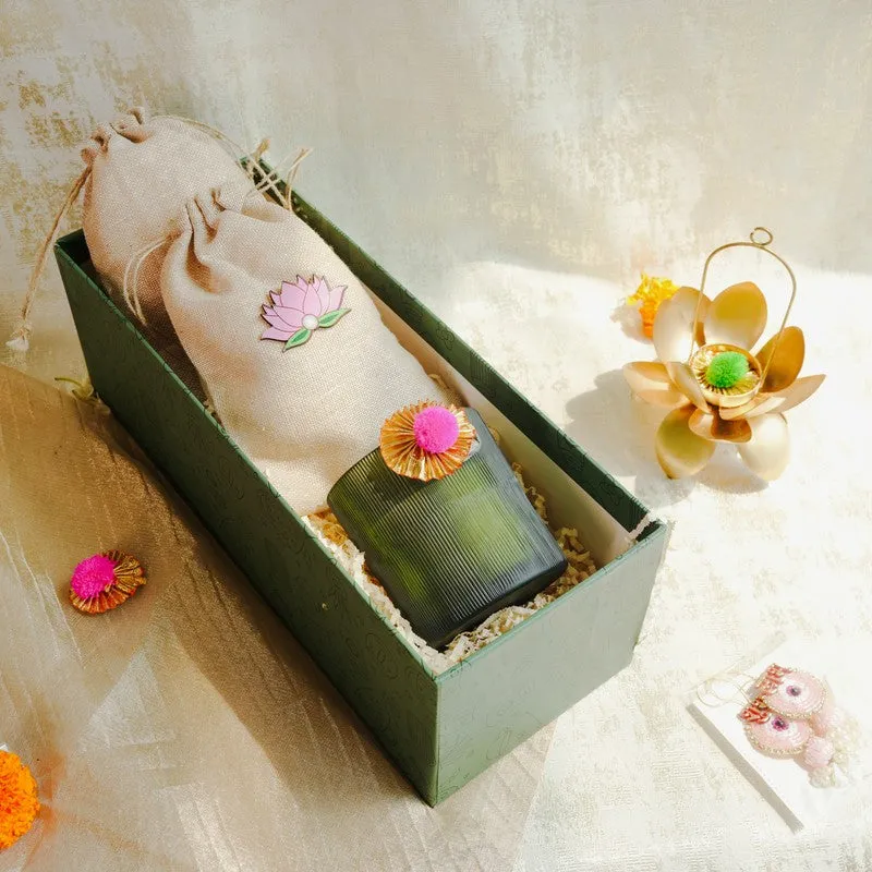 Lotus potli and ribbed candle arranged inside a green festive gift box