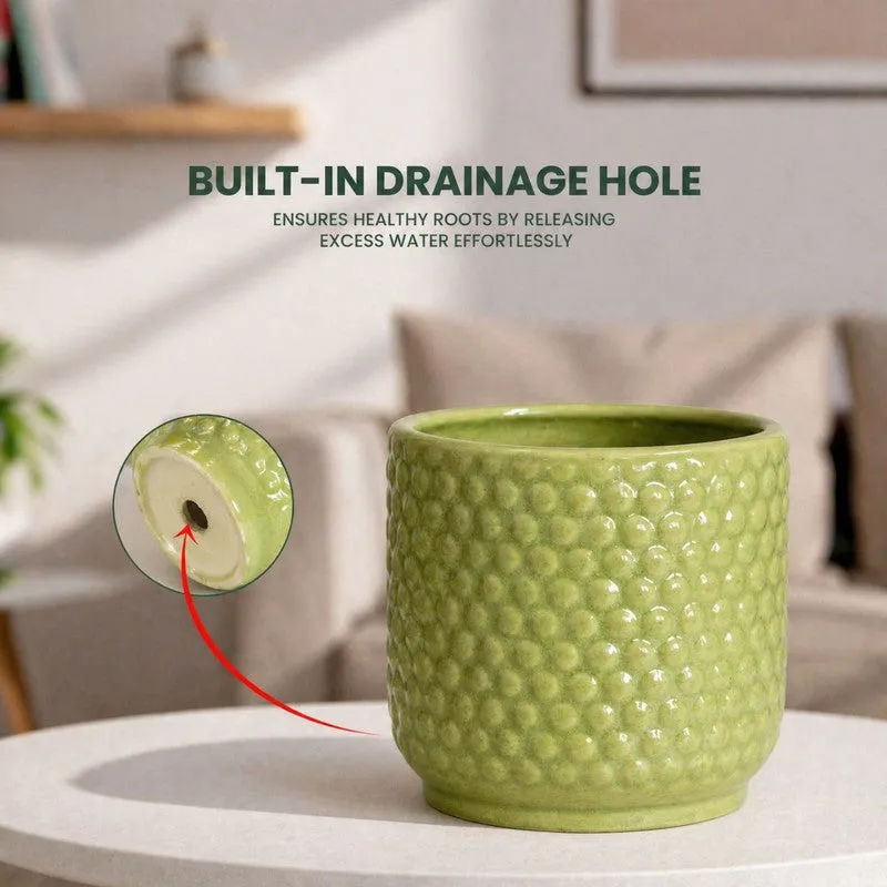 Green ceramic planter with visible drainage opening at the base