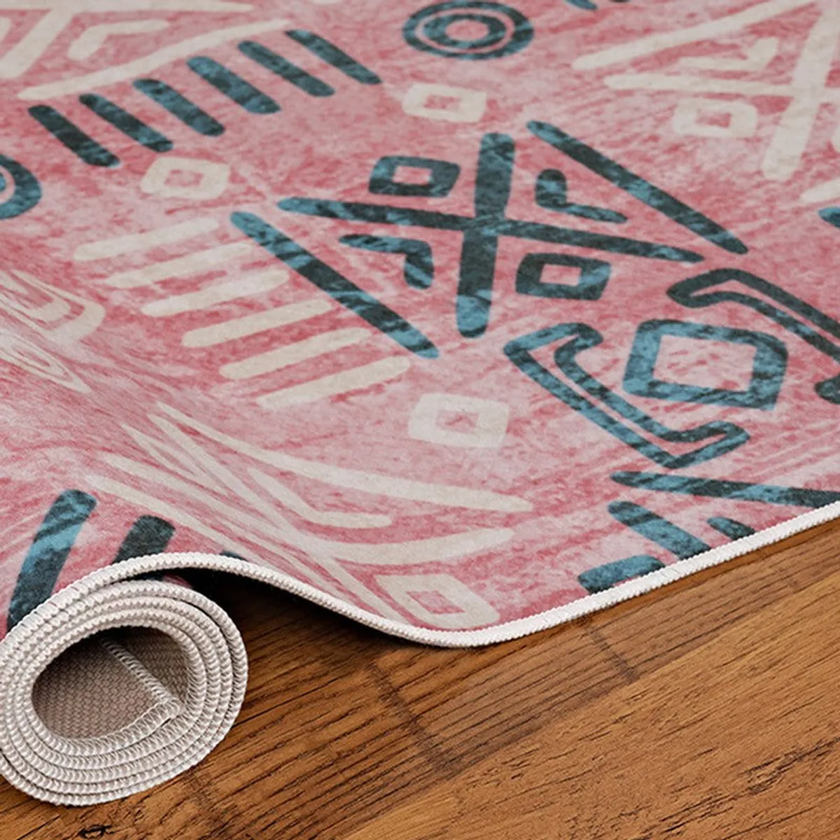 Rolled corner of pink abstract carpet showing edge finish