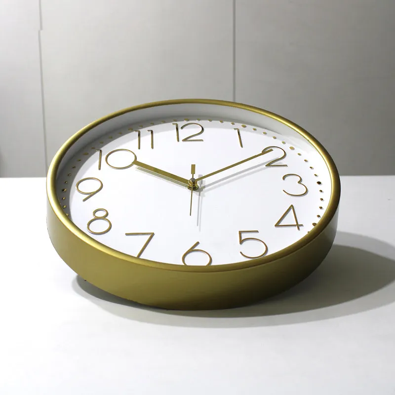 Close-up of the round gold clock case and white dial