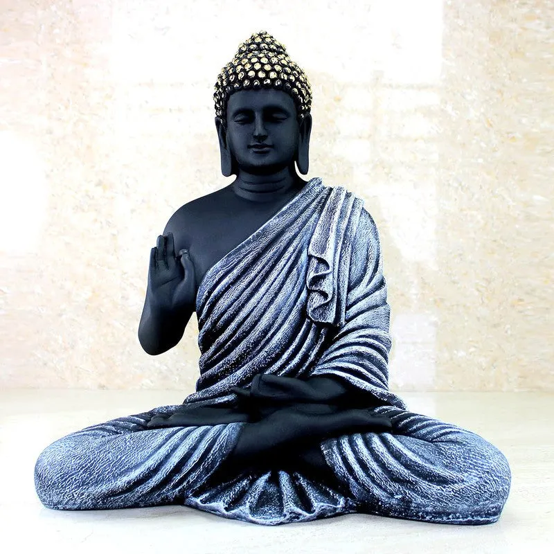 Front close view of seated Buddha idol with textured silver robe