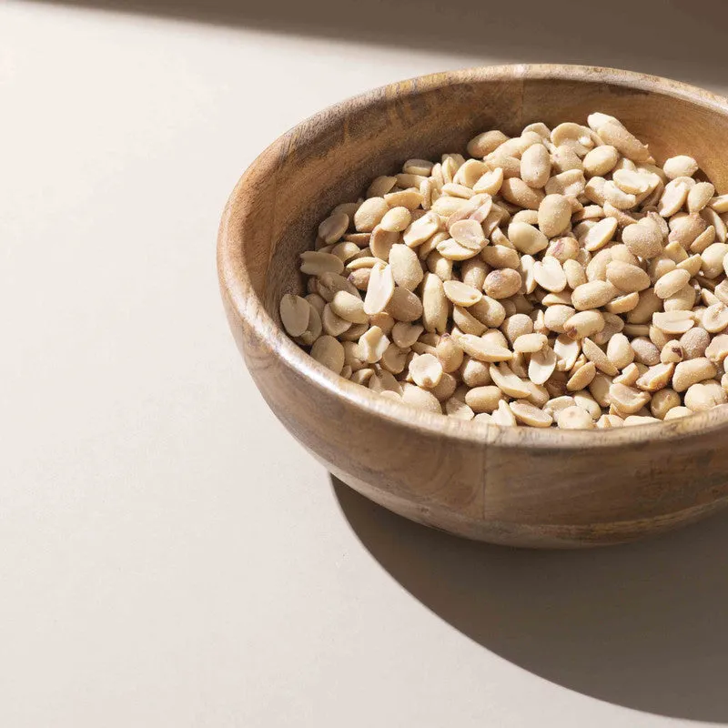 Close-up of the brown wooden bowl filled with peanuts