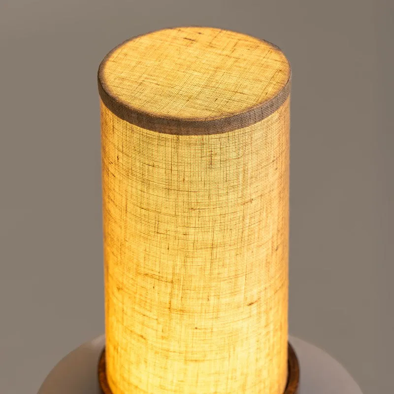 Close-up of the lit top section of the cylindrical beige lamp