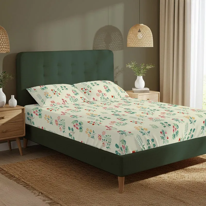 White and green floral fitted bedsheet styled on a dark green bed