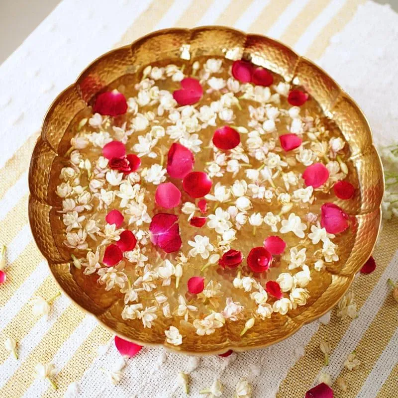 Top view of gold urli with floating flowers and rose petals