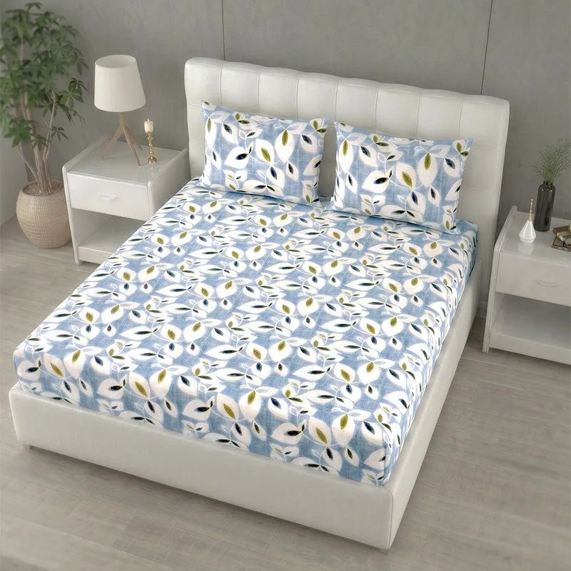 Angled view of blue printed bedsheet set on a white upholstered bed