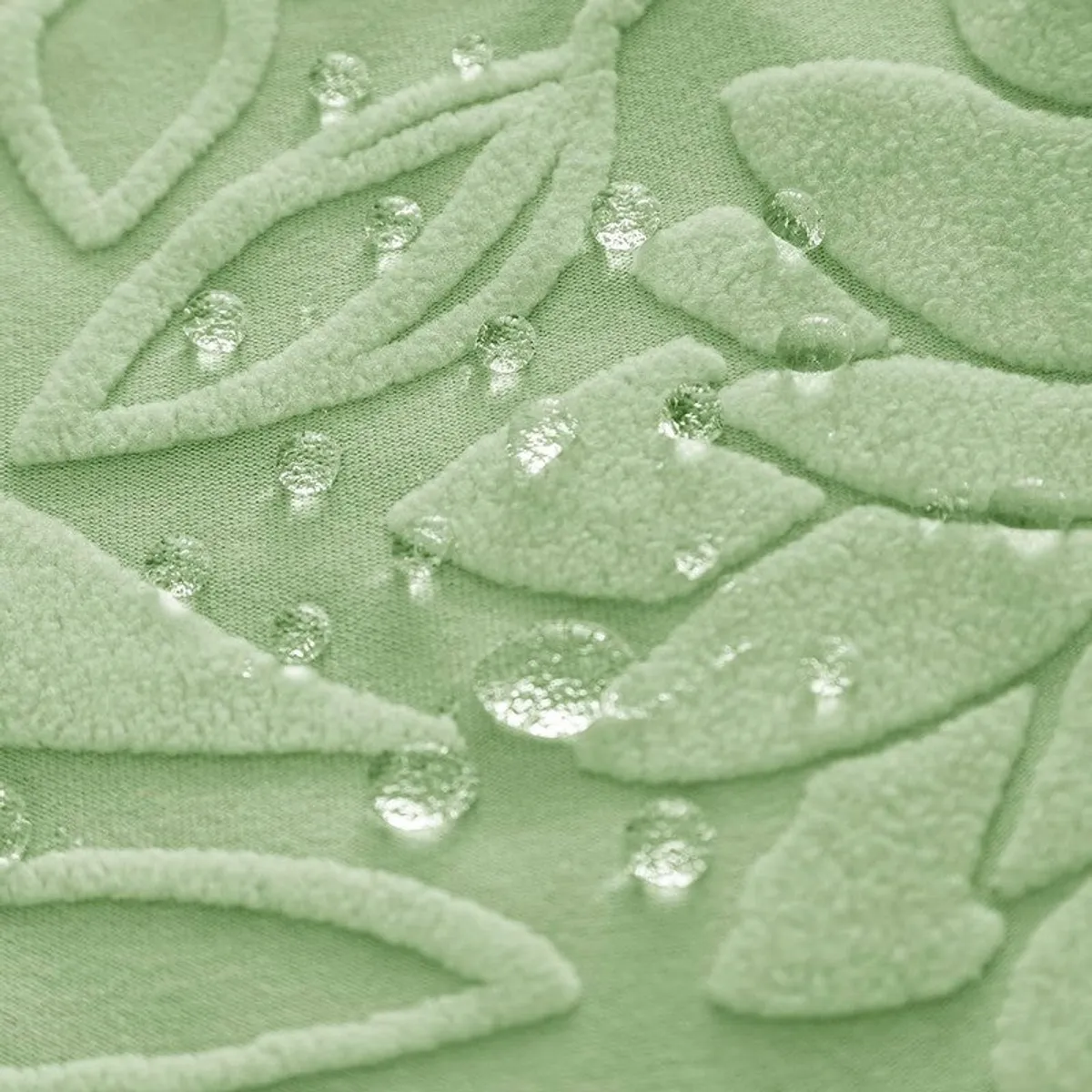 Close-up of light green textured chair cover fabric with water droplets