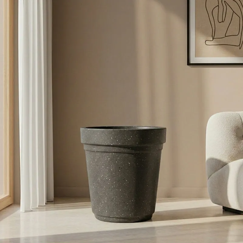 Empty black speckled planter with a tapered cylindrical shape