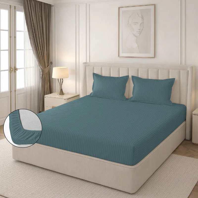 Teal striped fitted bedsheet on a bed with two matching pillow covers