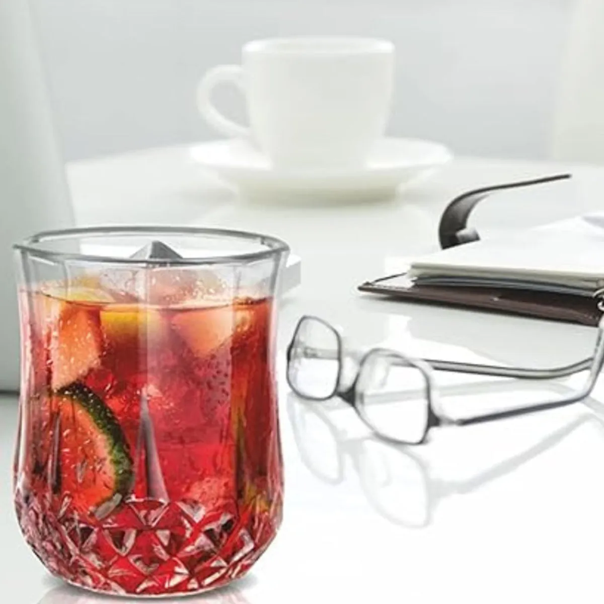 Clear textured glass with a red drink and citrus garnish on a table