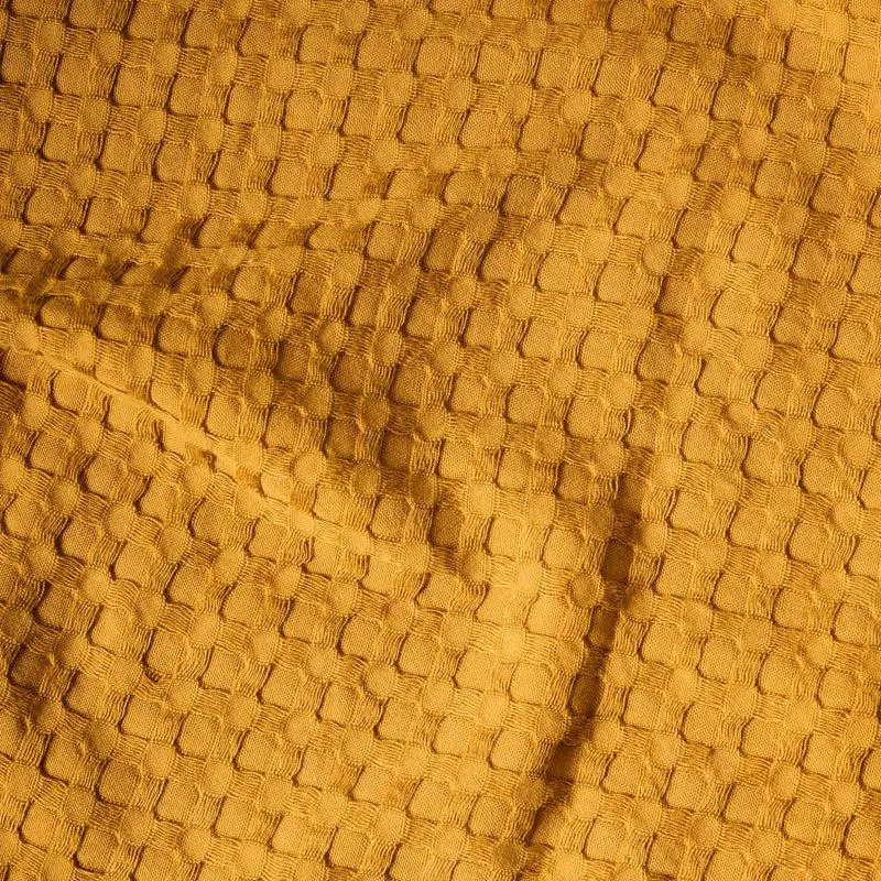 Close-up of yellow waffle-textured towel fabric