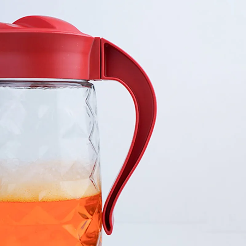 Close-up of red handle on transparent textured glass jug