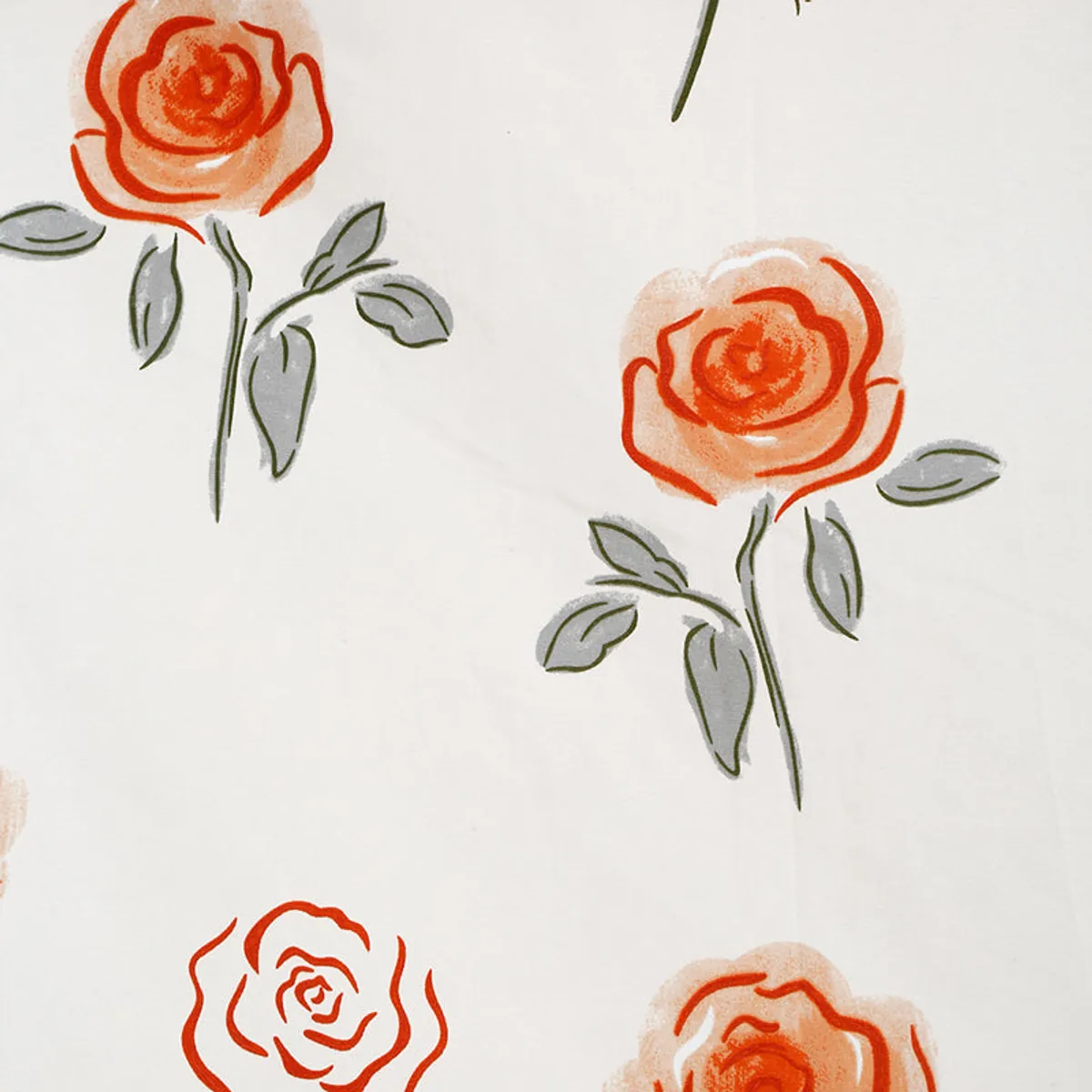 Detailed view of red-orange rose and grey leaf motifs on ivory fabric