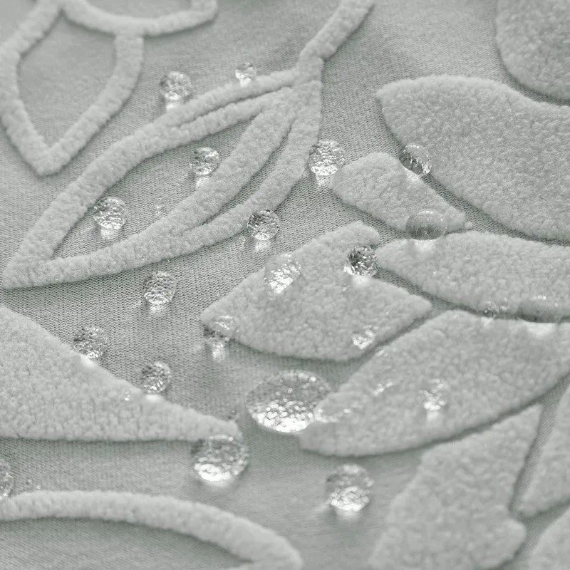 Close-up of light grey floral textured chair cover fabric with water droplets